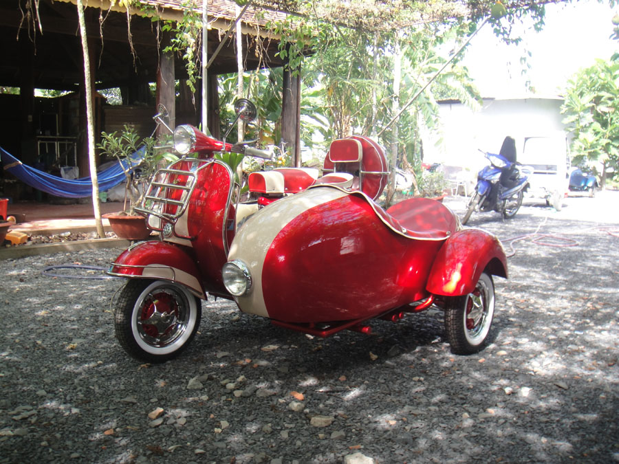 Red and white Vespa VBB sidecar during final workshop inspection before export from Vietnam